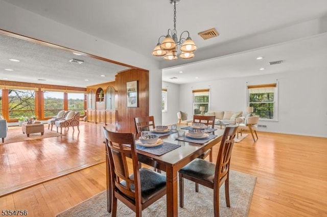 dining room with a healthy amount of sunlight, light wood finished floors, and visible vents