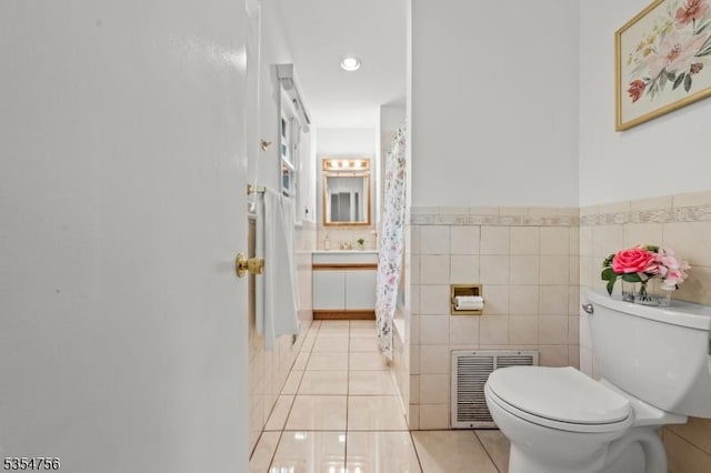bathroom with a shower with curtain, visible vents, tile walls, tile patterned flooring, and toilet