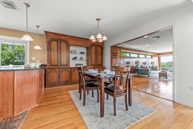 dining room featuring a notable chandelier, visible vents, and light wood-style floors