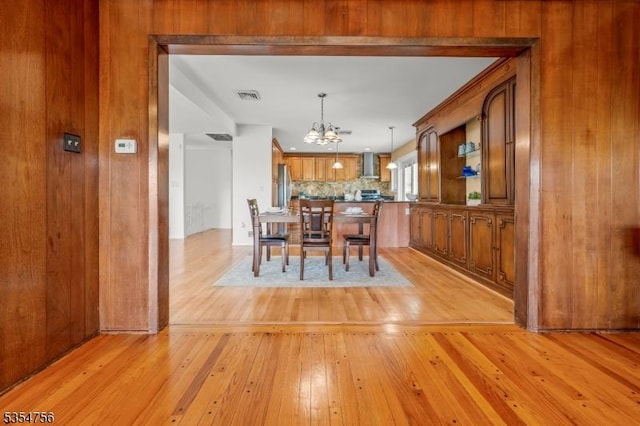 dining area featuring an inviting chandelier, light wood-style flooring, and visible vents