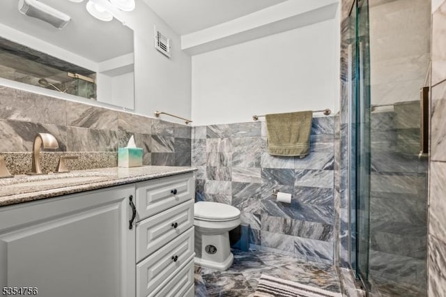 full bath featuring vanity, a shower stall, visible vents, and tile walls