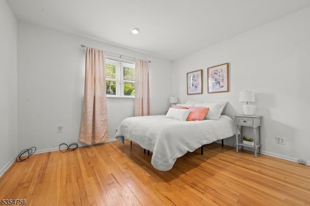 bedroom featuring baseboards and light wood-style floors