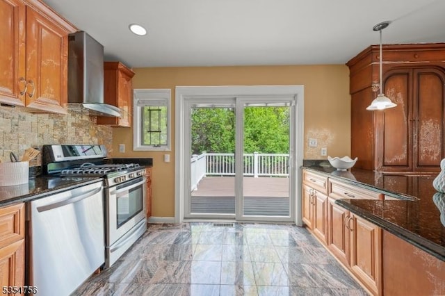 kitchen featuring wall chimney range hood, appliances with stainless steel finishes, marble finish floor, tasteful backsplash, and pendant lighting