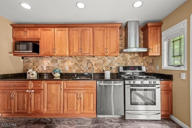 kitchen featuring a sink, stainless steel appliances, brown cabinets, and wall chimney exhaust hood