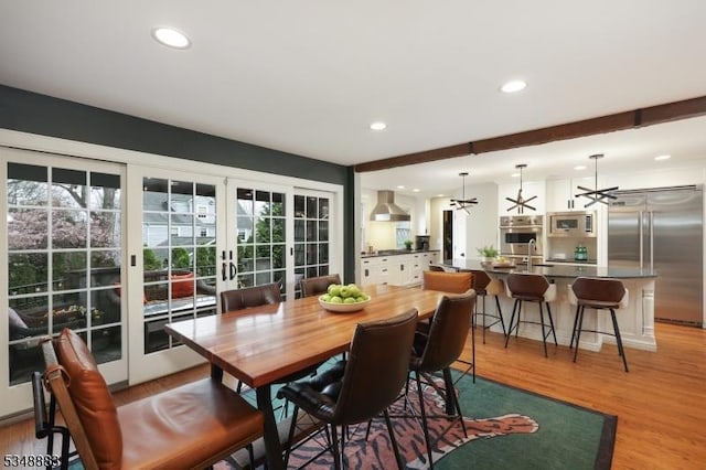 dining area with french doors, recessed lighting, a wealth of natural light, and light wood-type flooring