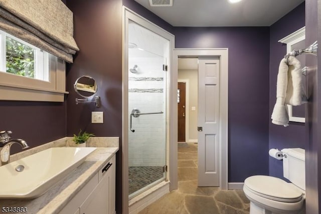 full bath featuring vanity, toilet, baseboards, and a stall shower