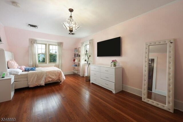 bedroom featuring dark wood-style flooring, baseboards, visible vents, and a chandelier