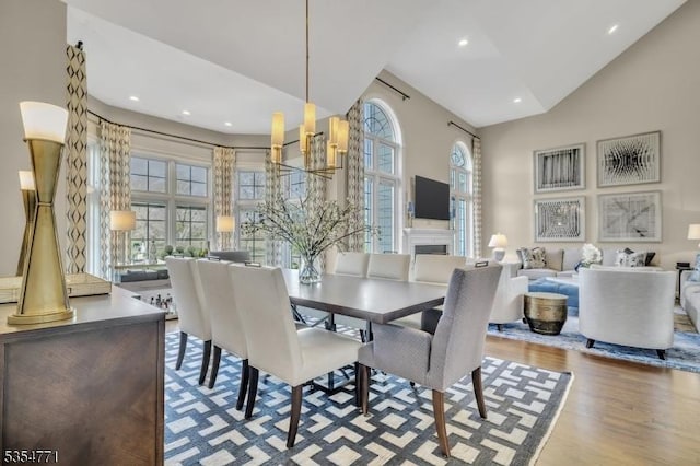dining area with recessed lighting, wood finished floors, and high vaulted ceiling