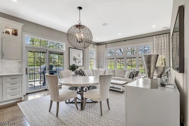 dining space featuring plenty of natural light, recessed lighting, light wood-style flooring, and an inviting chandelier