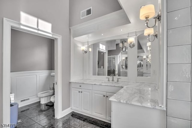 full bathroom with toilet, visible vents, a wainscoted wall, and vanity