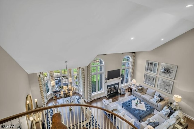 living room featuring a fireplace, recessed lighting, wood finished floors, and lofted ceiling