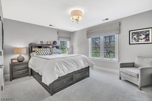 carpeted bedroom featuring baseboards and visible vents
