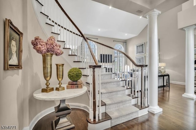 stairway with ornate columns, baseboards, recessed lighting, and wood finished floors