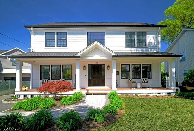view of front of house with covered porch and a front lawn