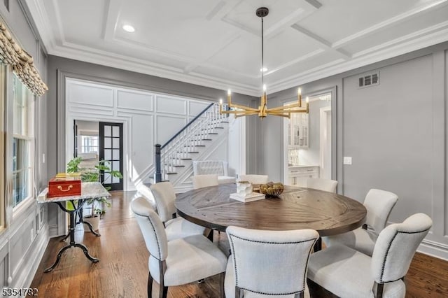 dining space with visible vents, crown molding, dark wood finished floors, coffered ceiling, and stairs