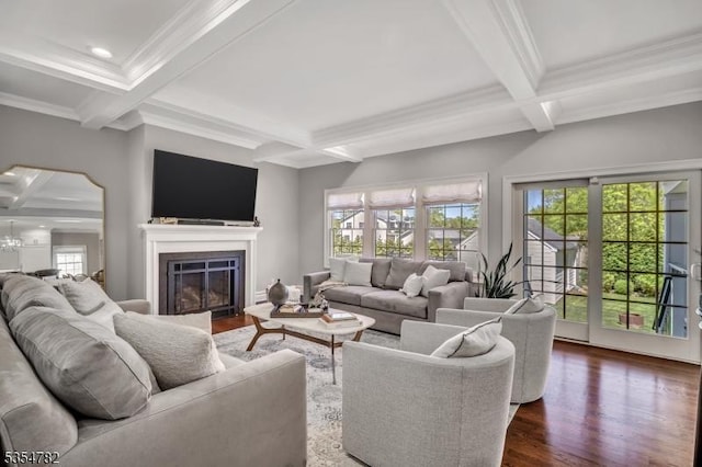 living room with dark wood finished floors, beam ceiling, a glass covered fireplace, ornamental molding, and coffered ceiling