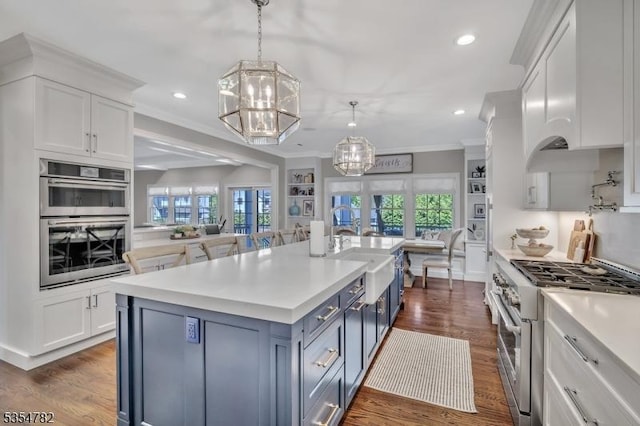 kitchen with light countertops, white cabinetry, a chandelier, a sink, and stainless steel appliances