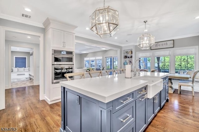 kitchen featuring white cabinets, ornamental molding, and a notable chandelier