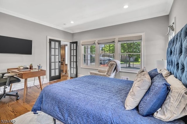 bedroom featuring french doors, ornamental molding, wood finished floors, and recessed lighting