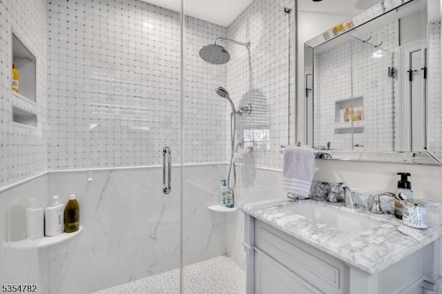 full bathroom featuring vanity and a marble finish shower