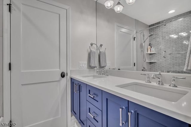 bathroom with a sink, double vanity, and tiled shower