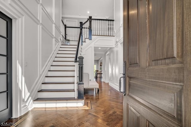 foyer entrance featuring stairs, recessed lighting, ornamental molding, and a decorative wall