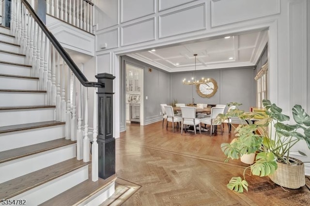 interior space with crown molding, an inviting chandelier, and a decorative wall