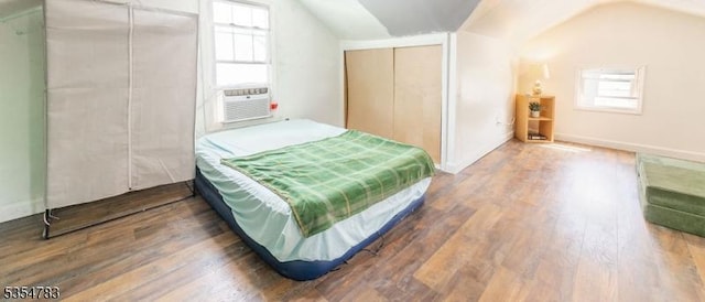 bedroom featuring cooling unit, vaulted ceiling, and wood finished floors