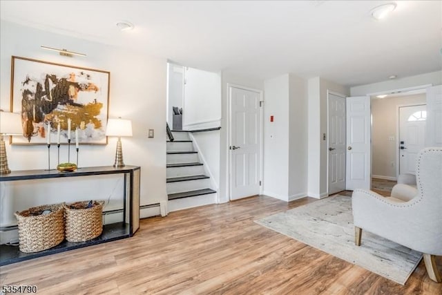 interior space featuring baseboards, light wood finished floors, and stairway