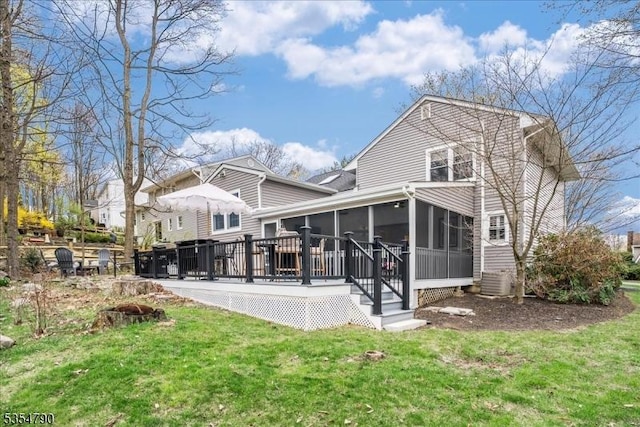 back of house featuring a sunroom, central air condition unit, a yard, and a deck