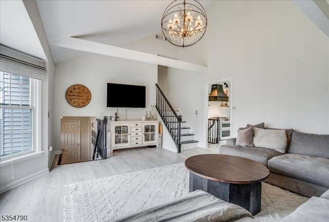 living area with visible vents, wood finished floors, stairway, baseboards, and a notable chandelier