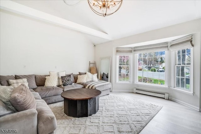 living room featuring wood finished floors, baseboards, a baseboard radiator, a notable chandelier, and vaulted ceiling