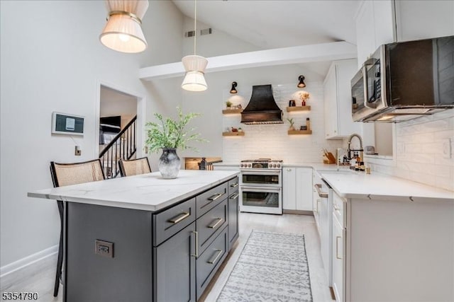 kitchen with appliances with stainless steel finishes, a sink, gray cabinets, tasteful backsplash, and custom exhaust hood