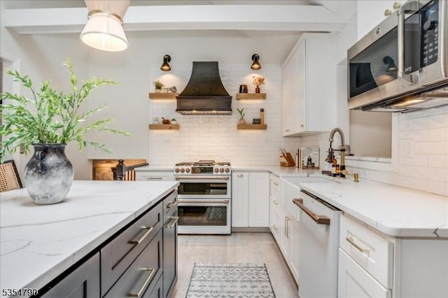 kitchen with tasteful backsplash, open shelves, premium range hood, white cabinets, and stainless steel appliances