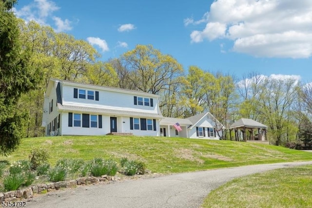 view of front of house featuring a gazebo, driveway, and a front yard