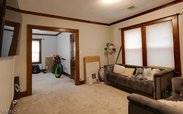 living area with visible vents, baseboards, crown molding, and light colored carpet