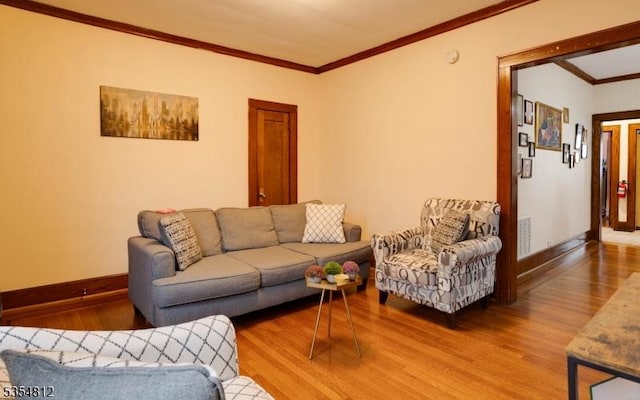 living room with crown molding, baseboards, visible vents, and wood finished floors