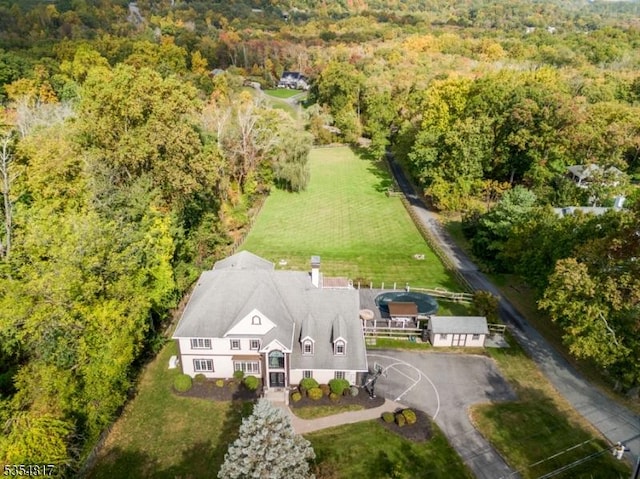 bird's eye view with a wooded view
