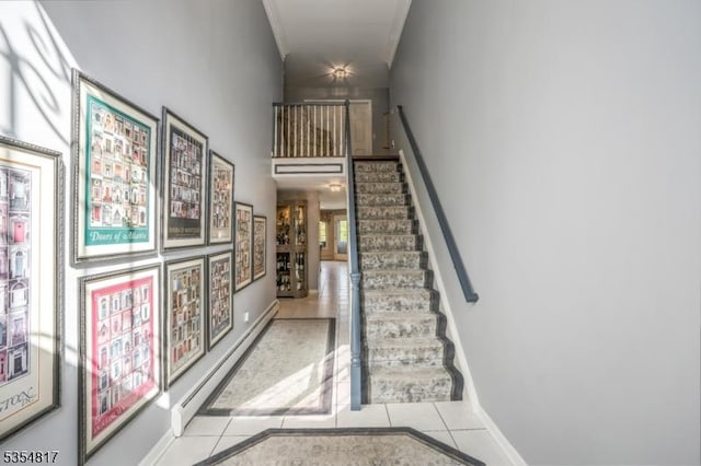stairs with tile patterned flooring, a baseboard radiator, baseboards, and ornamental molding
