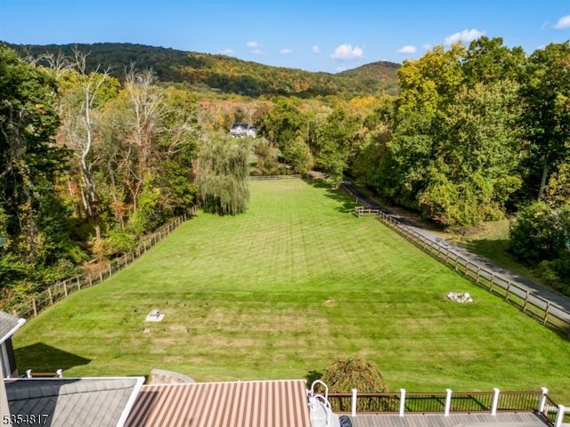 view of yard featuring fence and a forest view