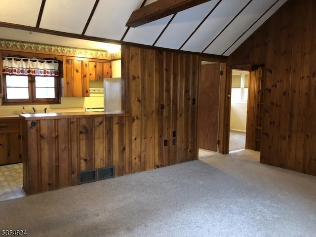 218 Wawayanda Rd, Vernon Twp, NJ 07422 - kitchen with visible vents, wood walls, freestanding refrigerator, lofted ceiling, and a sink