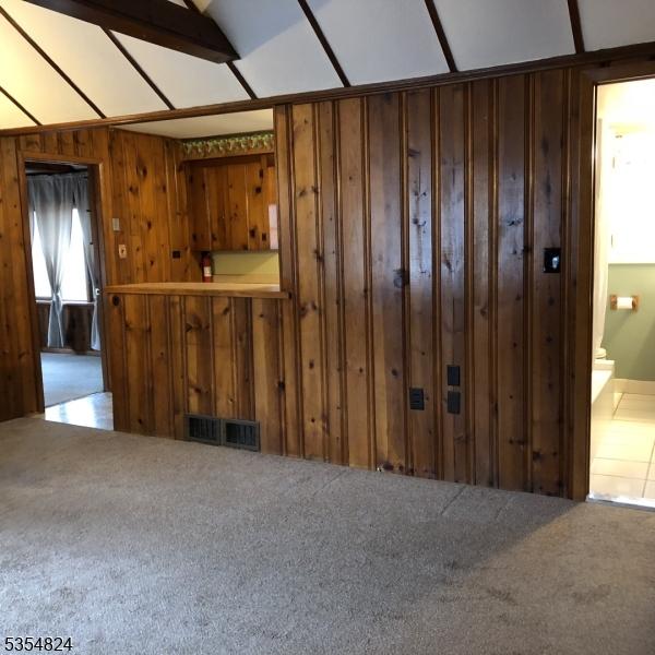 218 Wawayanda Rd, Vernon Twp, NJ 07422 - unfurnished living room featuring carpet floors, wood walls, and visible vents