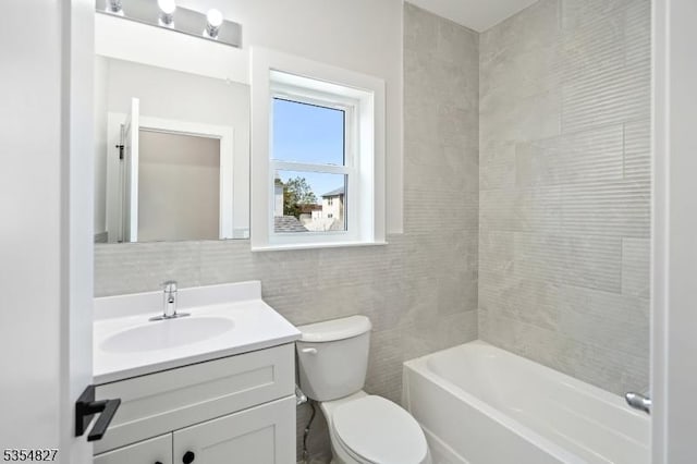 bathroom with vanity, tasteful backsplash, toilet, and tile walls