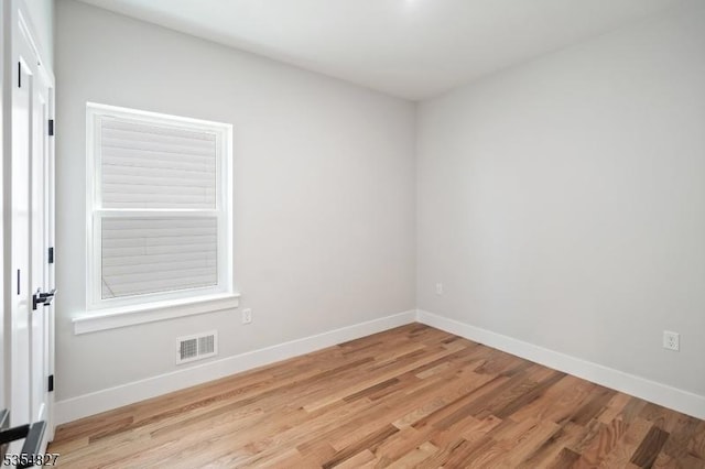 unfurnished room with baseboards, visible vents, and light wood-type flooring