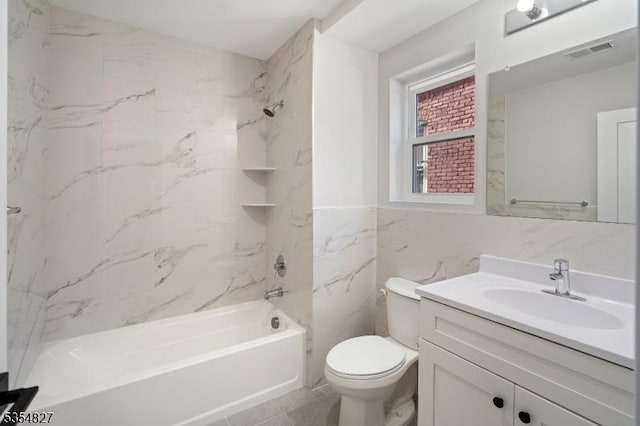 bathroom with visible vents, tile walls, vanity, toilet, and tub / shower combination