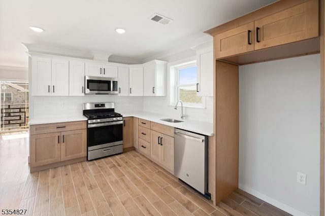 kitchen with visible vents, a sink, backsplash, and stainless steel appliances