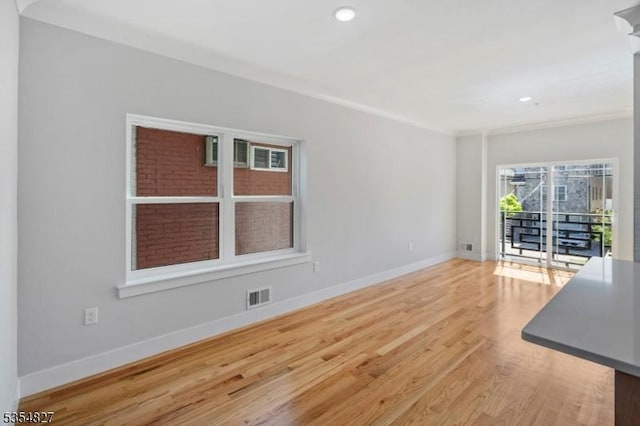 unfurnished living room featuring recessed lighting, baseboards, wood finished floors, visible vents, and ornamental molding