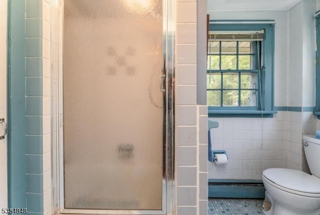 bathroom with tile patterned flooring, tile walls, toilet, and a shower stall