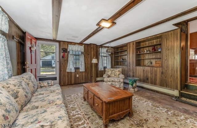 living area with wood walls, built in shelves, a baseboard heating unit, and beam ceiling