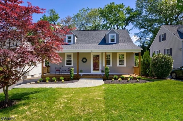 cape cod home featuring covered porch, a front yard, and a shingled roof